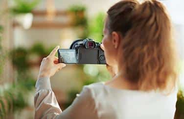 Frau hält professionelle Kamera in den Händen für Immobilienfotografie